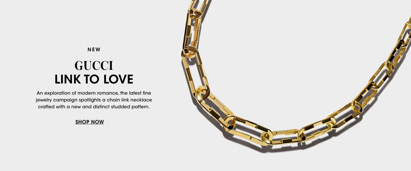 1 photo, a closeup of a Gucci gold chain link necklace over a plain grayish background.