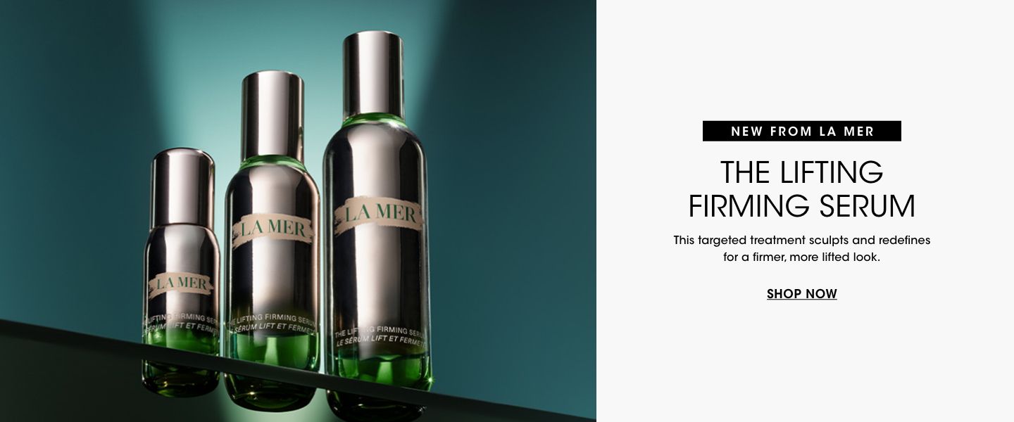 1 photo, of 3 different size bottles of La Mer the lifting firming serum on a glass surface with a dark green background.