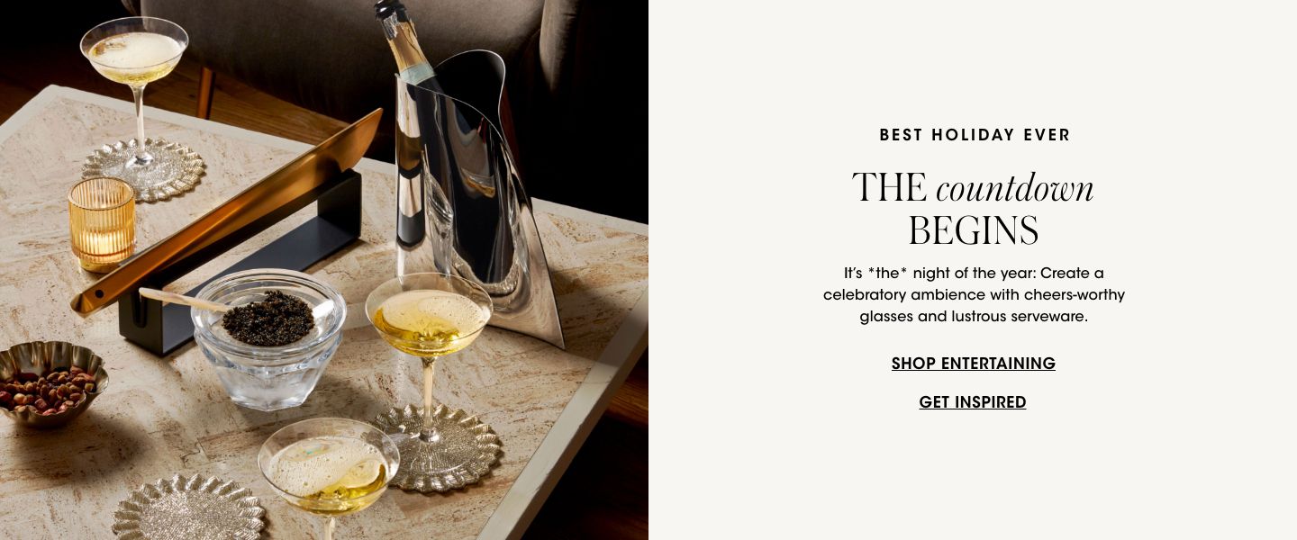 1 photo, of a cocktail table with coupes of champagne, a caviar dish, a champagne bottle in a silver wine holder, a rose gold champagne saber, and a bowl filled with nuts.