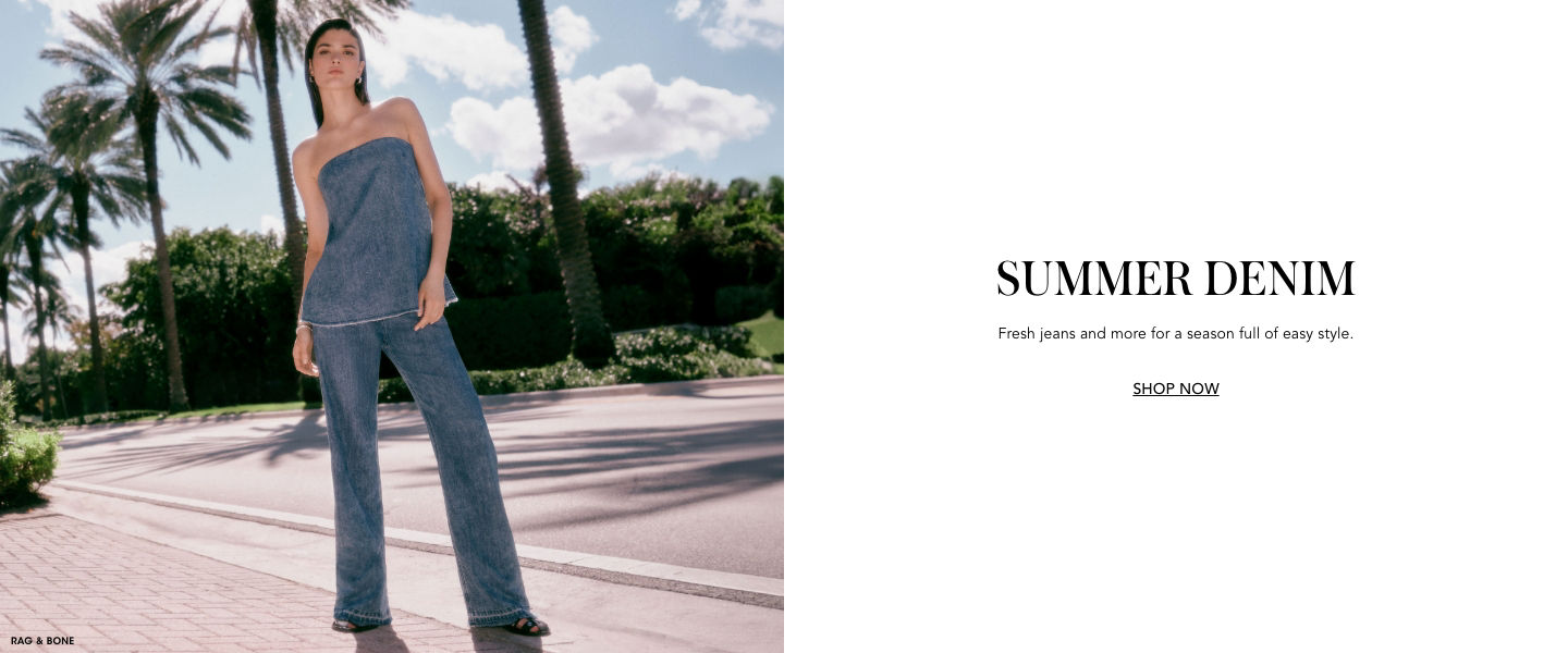 1 photo, of a female model standing on a sidewalk next to a street lined with palm trees, blue sky behind them, in matching Rag and Bone blue denim jeans and strapless top.