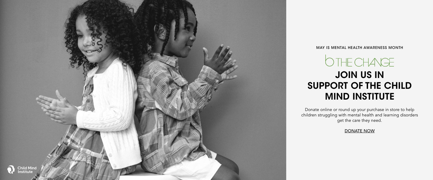 1 black and white photo, of a smiling little girl and little boy sitting back to back, with hands in a clapping motion.