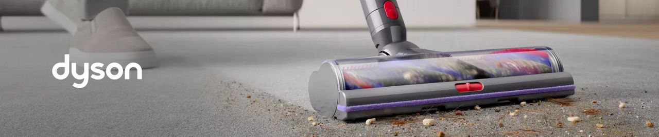 1 photo, a closeup of a Dyson vacuum cleaner cleaning a dirty gray carpet.