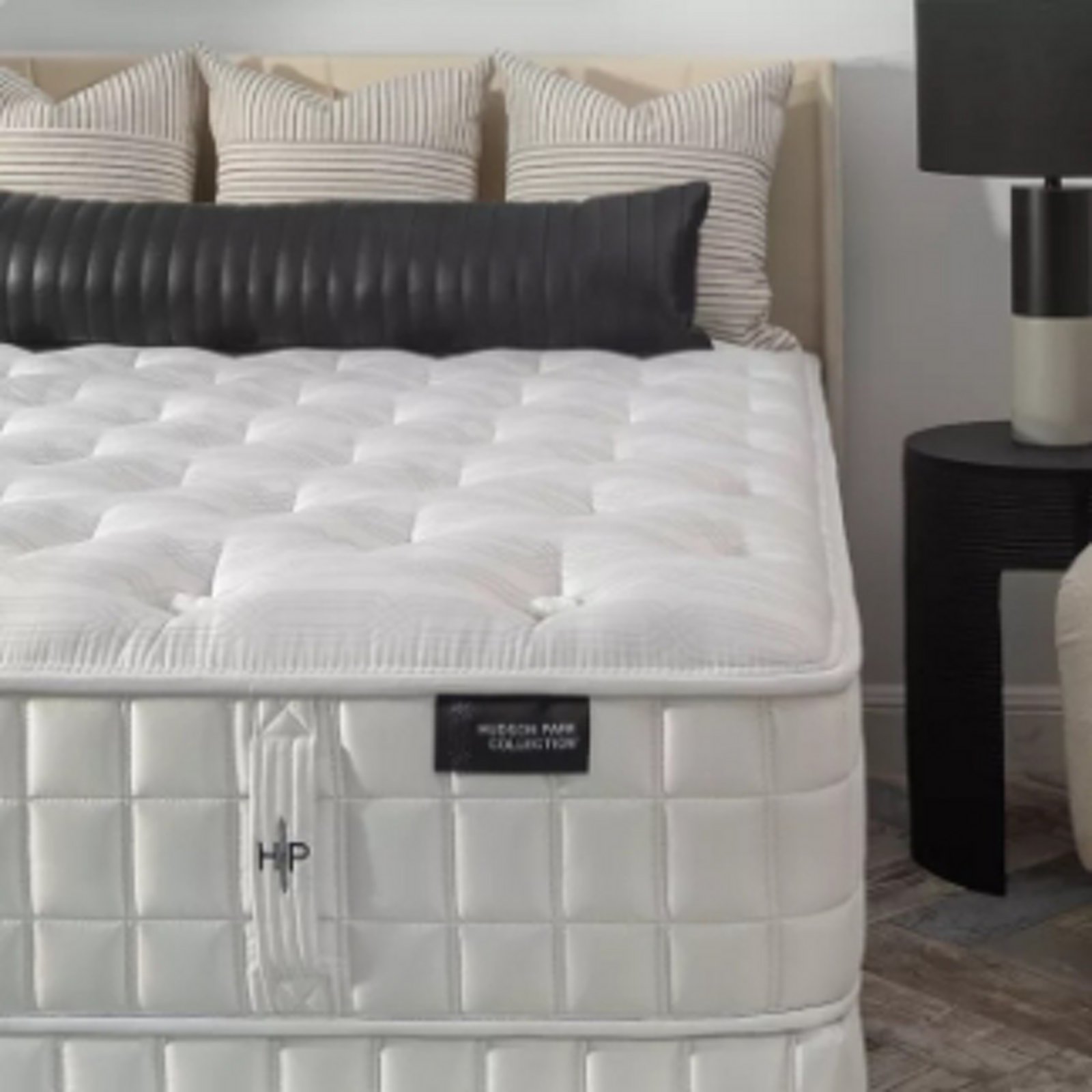 1 photo of Hudson Park mattress adorned with four accent pillows, on top.