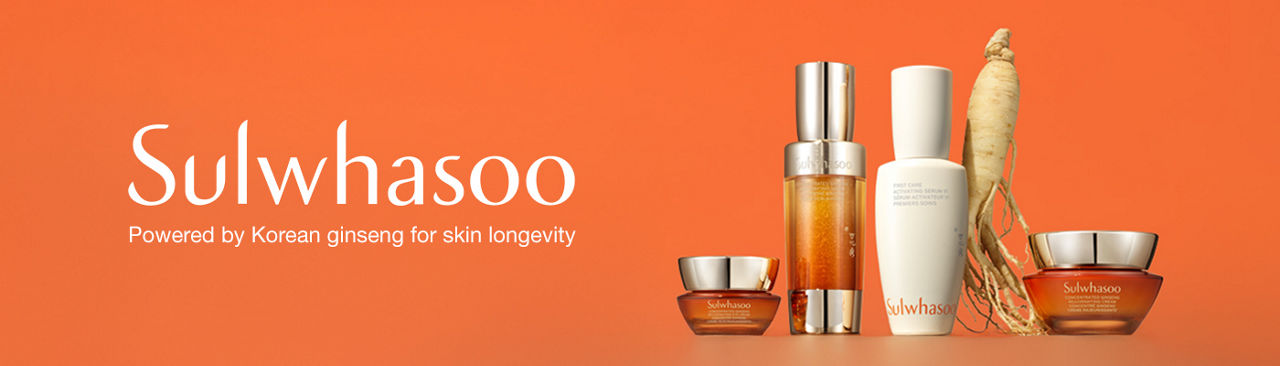 1 photo, of various orange and white bottles of Sulwhasoo skincare lined up in front of an orange background, a large ginseng root between 2 bottles.
