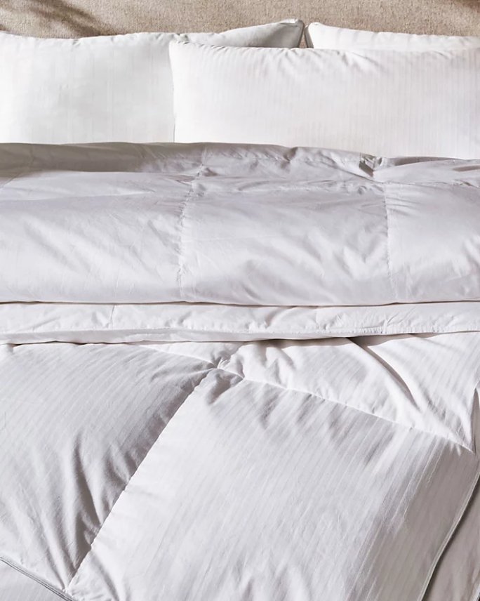 White comforters layered a stop each other.
