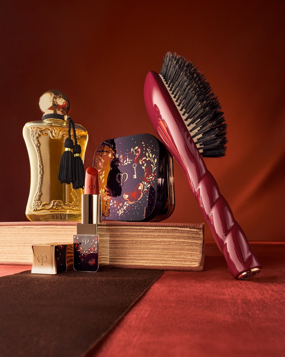 A fragrance bottle, Cle de Peau Beaute makeup compact and lipstick, and hairbrush. The Valentines Day Shop, our best gifts.
