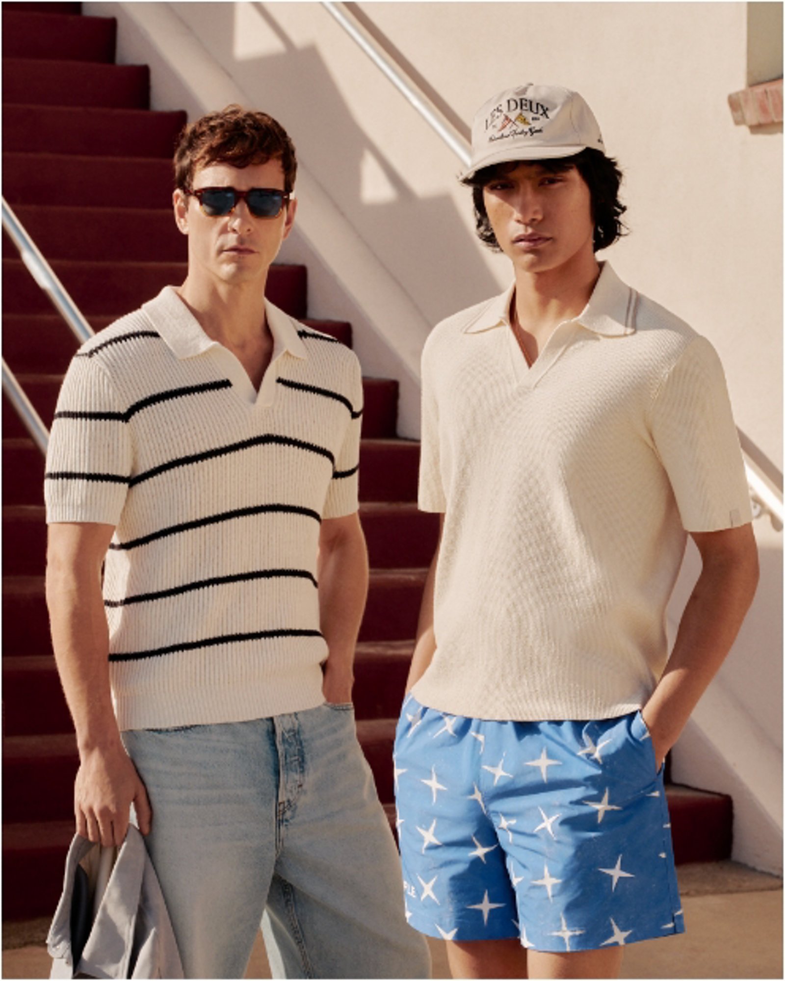 Two men standing next to each other, both in knit polos and shorts.