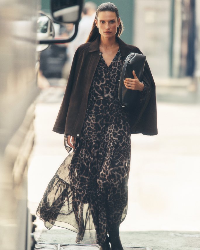 1 female model in leopard print dress, black boots, and black overcoat.