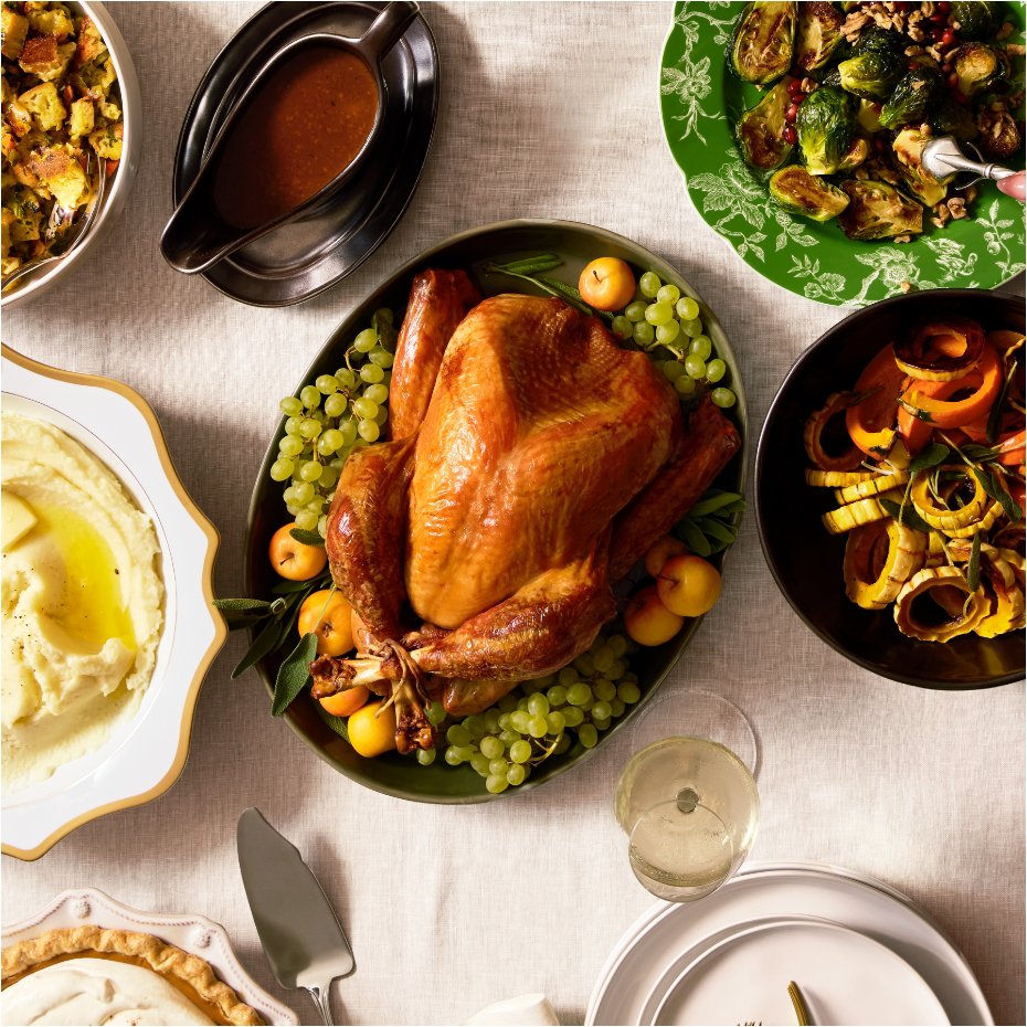Holiday table setting with cooked turkey in oval serveware dish.