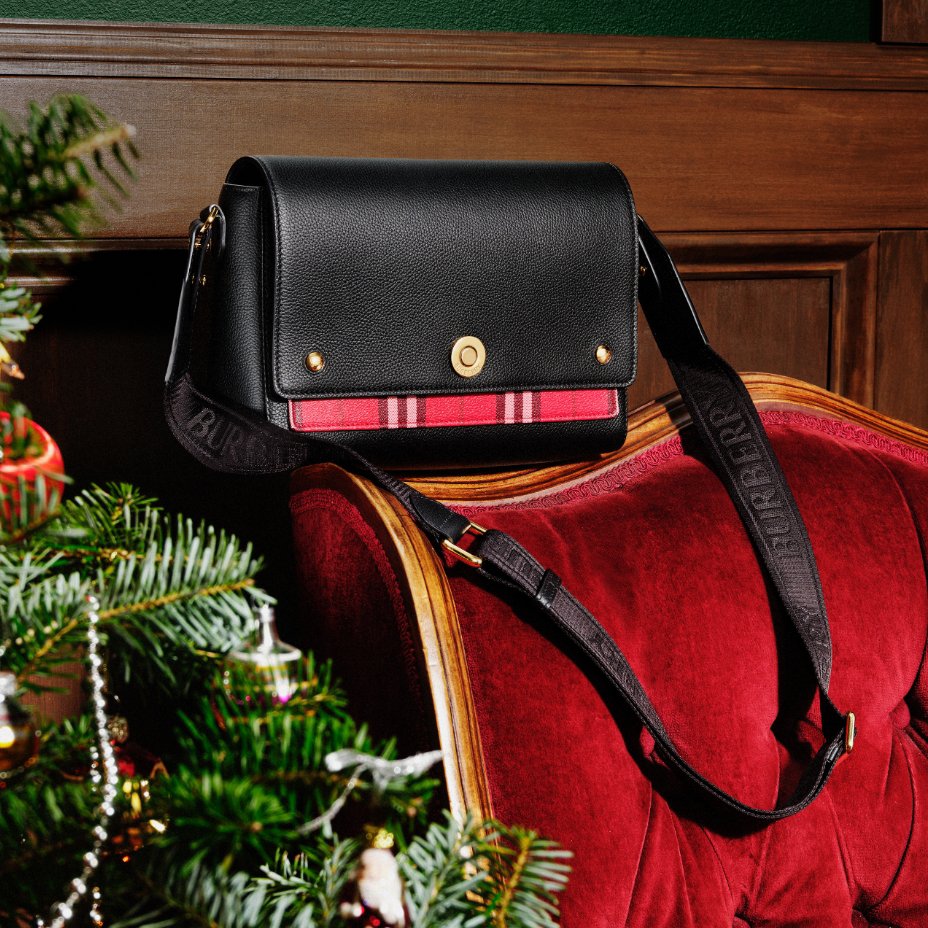 A black Burberry handbag with a stripe of red plaid.