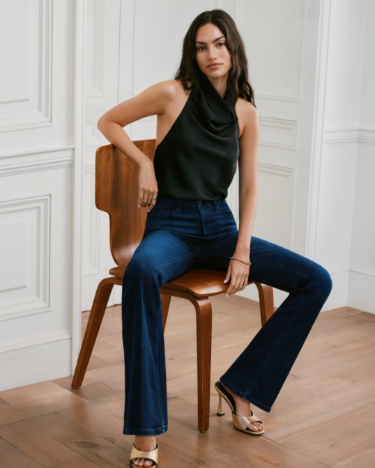 Woman in a sleeveless black top and dark blue jeans.