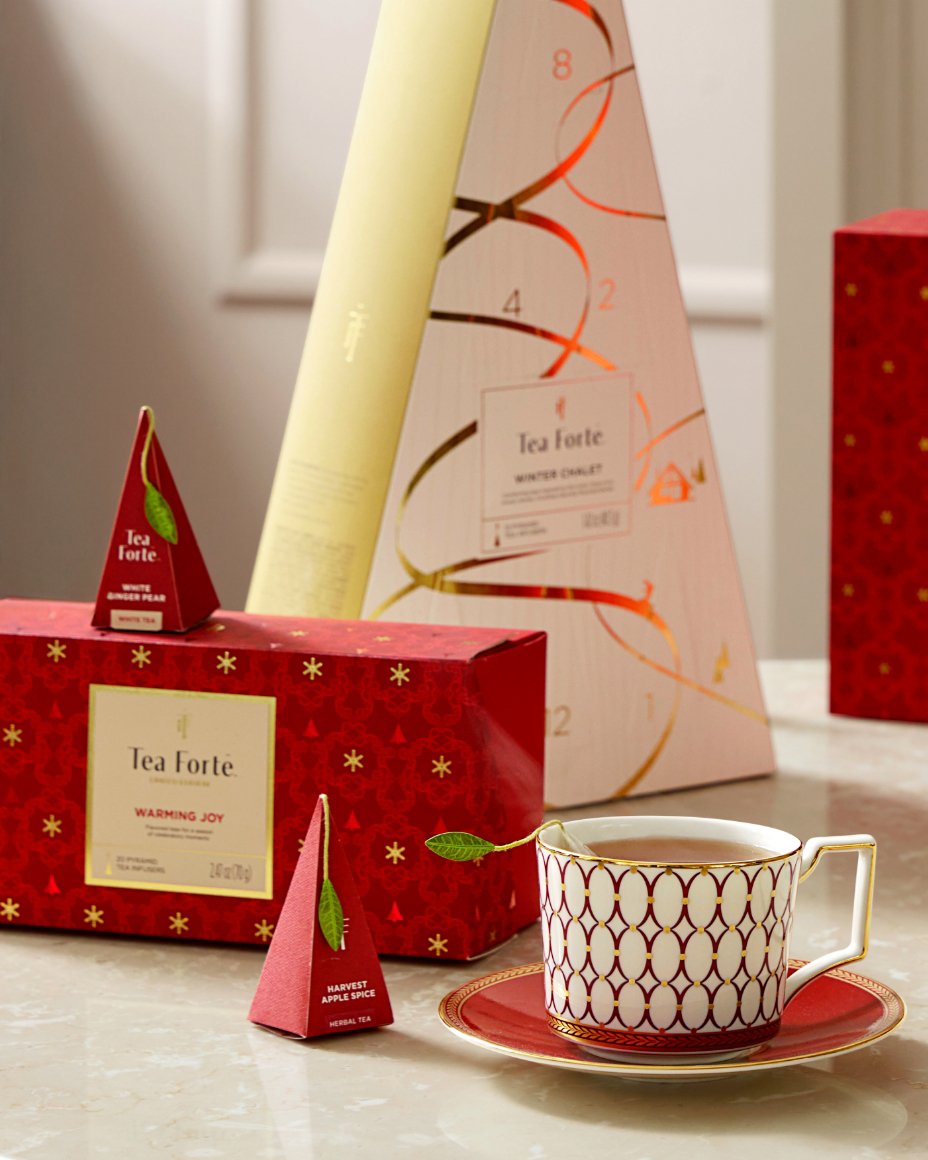 A stack of apples balanced against a large jar of olives.