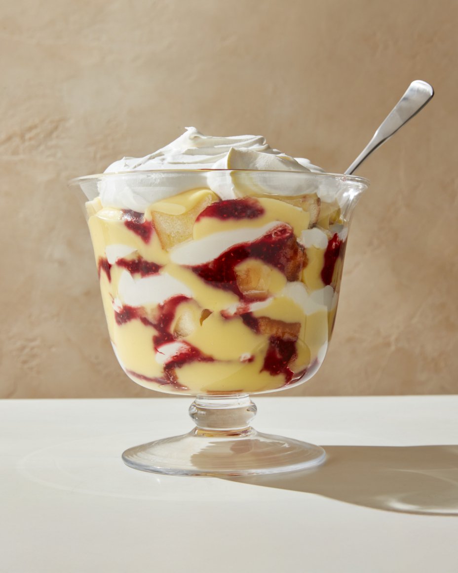 A side table filled with serve ware holding desserts, including a pumpkin pie and meringue cake.