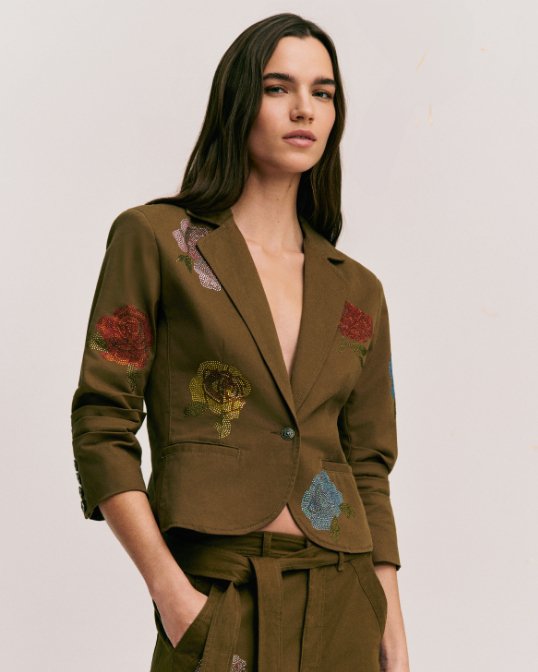 Female model in Cinq A Sept brown jacket and pant set, with retro love patches.