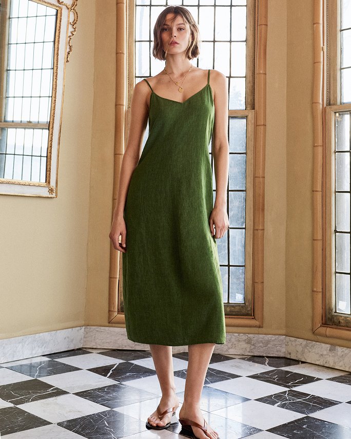 A woman in an Eileen Fisher green slip dress. Labels we love, Eileen Fisher.
