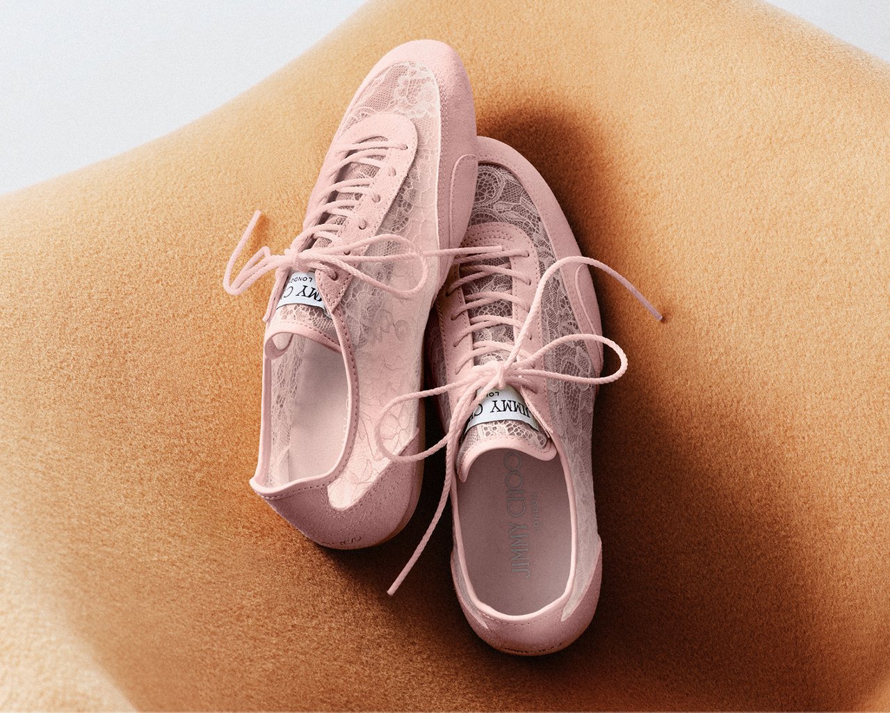 A pair of dusty pink lacy Jimmy Choo sneakers. Pastel season, Jimmy Choo.