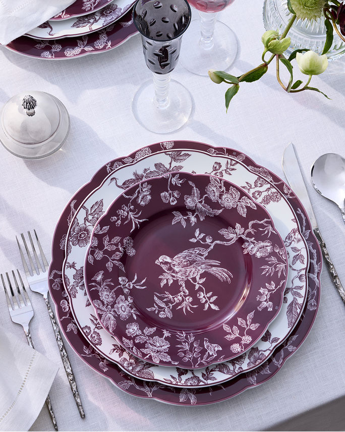 An elaborate deep purple and white floral patterned Bernardaud place setting. Shop Bernardaud.