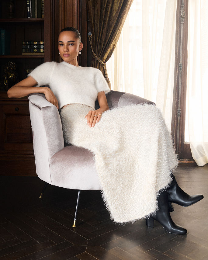A woman in a white textured Liberowe top and maxi skirt. The fall collections, Liberowe.