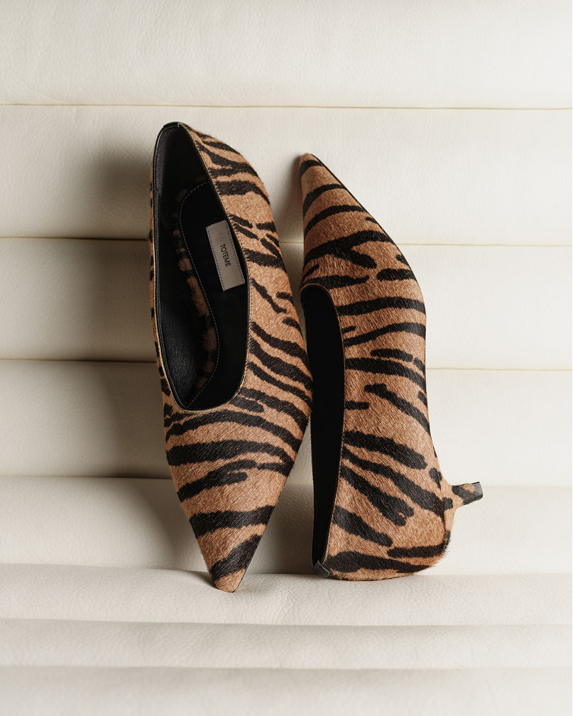 A pair of brown and black zebra stripe print pumps. Shop animal prints.