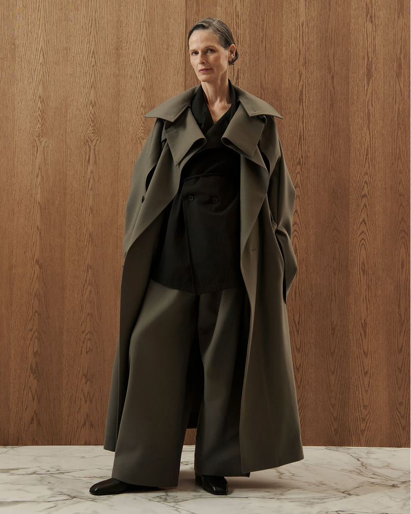 A woman in a brown structured trench coat. Shop architectural outerwear.