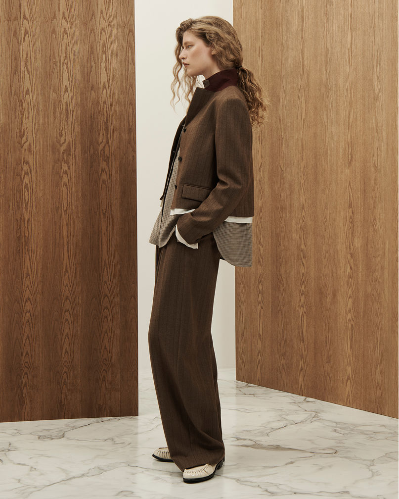A woman in a structured brown blazer and pants. Shop strong shoulders.