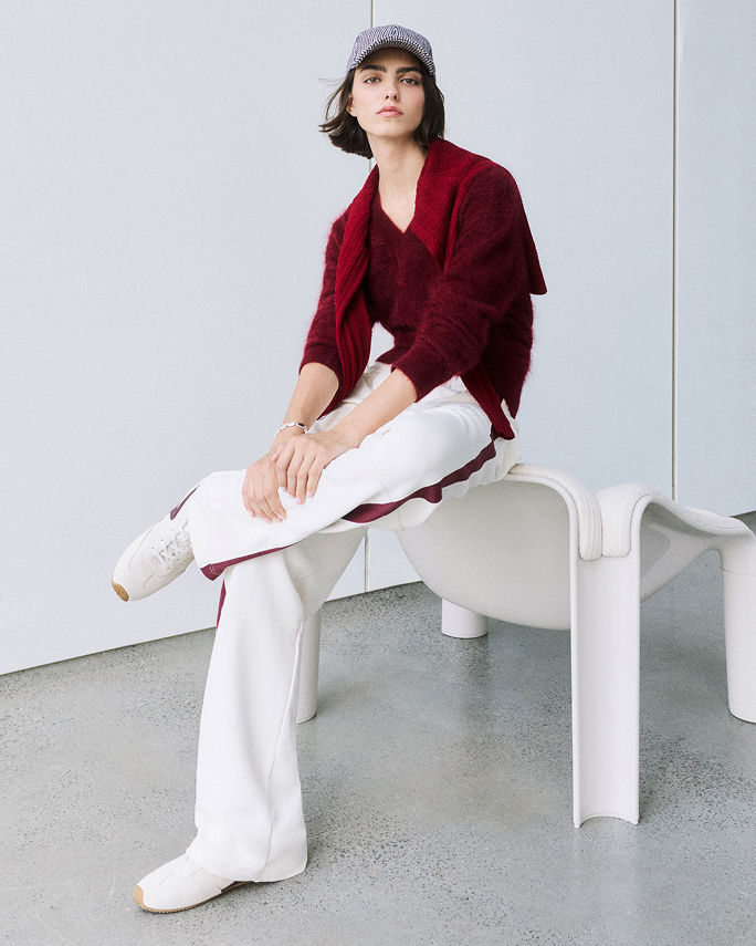 Featured shops. A woman in a blood red top and white pants. New & now.