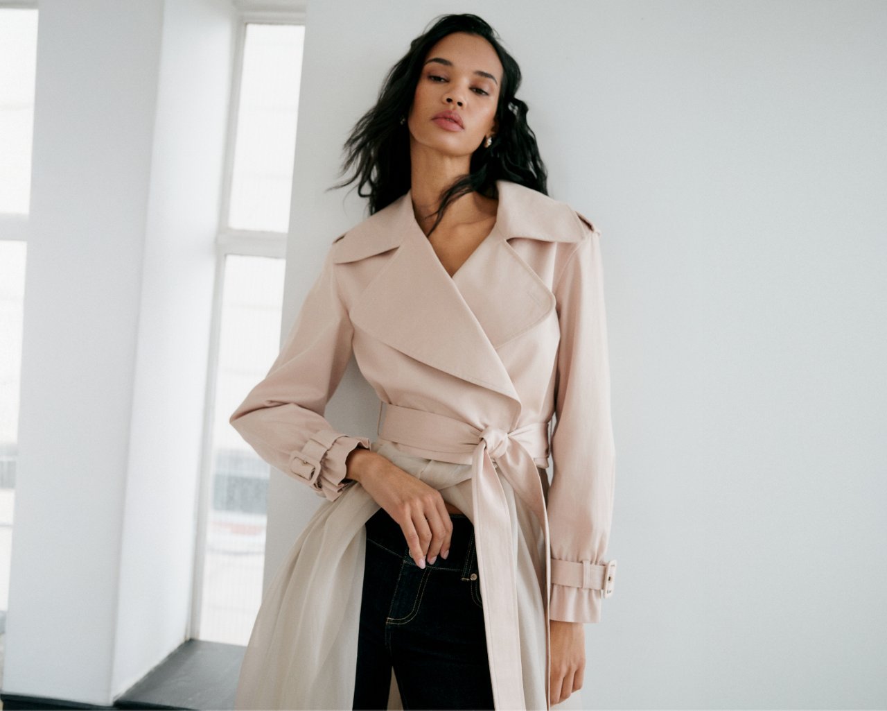 A woman in a pink trench top and black jeans. All new for spring. Shop womens new arrivals.