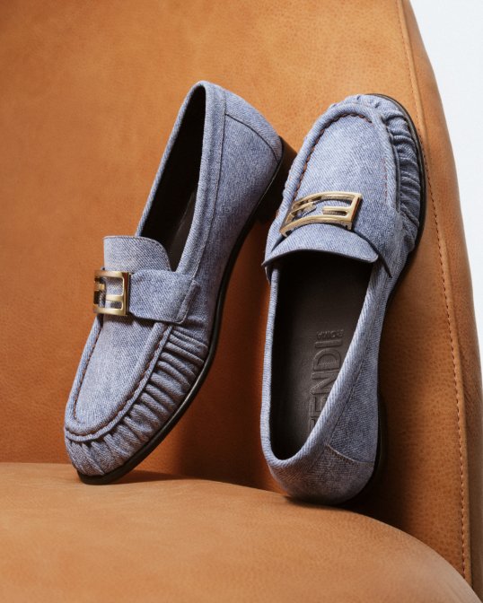 A pair of light blue denim Fendi loafers.