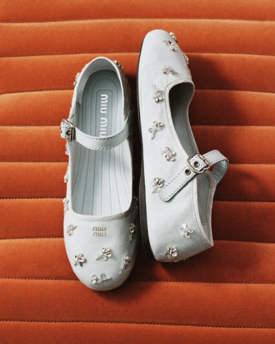 A pair of light blue Miu Miu ballet flats with crystal embellishments.