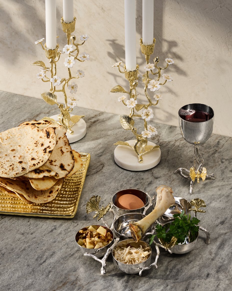 A marble tabletop with Michael Aram Bloom flower serveware, including candlestick holders & snack tray. Shop Passover.