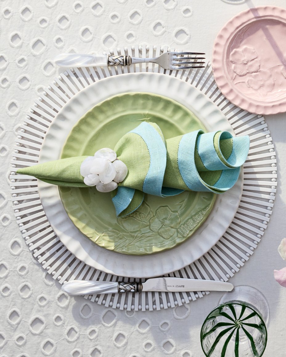 A place setting with green & white plates & a green napkin with flower napkin holder. Shop spring tabletop.