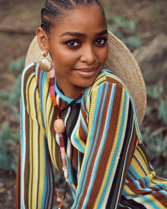 Woman in a multicolor striped, long sleeve knit dress.