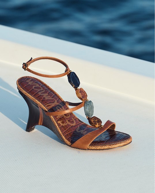 A single brown Stuart Weitzman platform sandal with beaded embellishment.