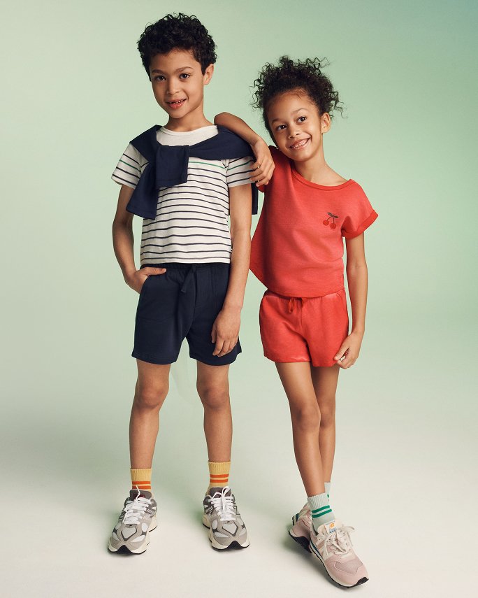 A young boy and girl in summery shorts and tees. The camp shop.