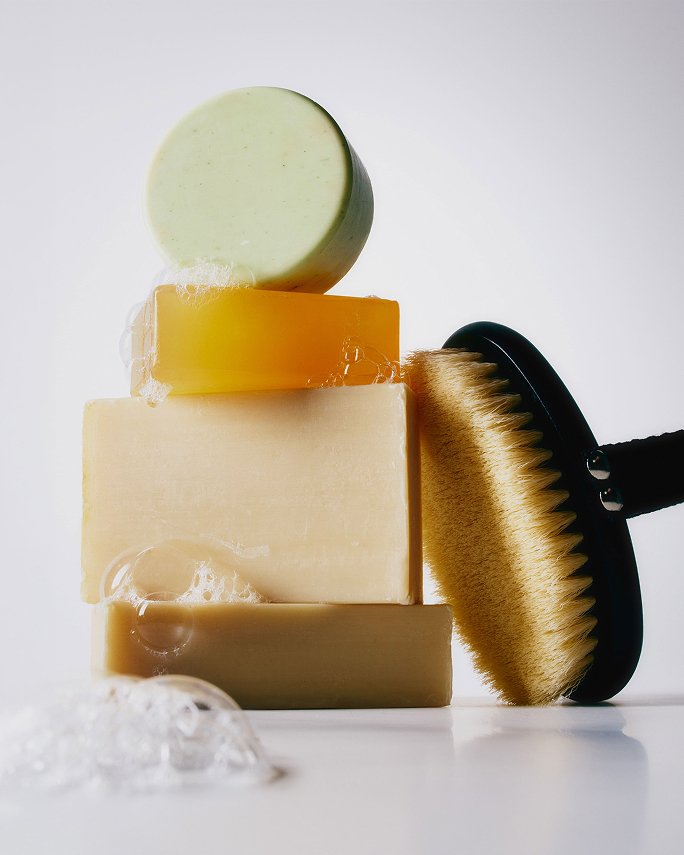 A stack of soaps and a body brush. The skincare guide.