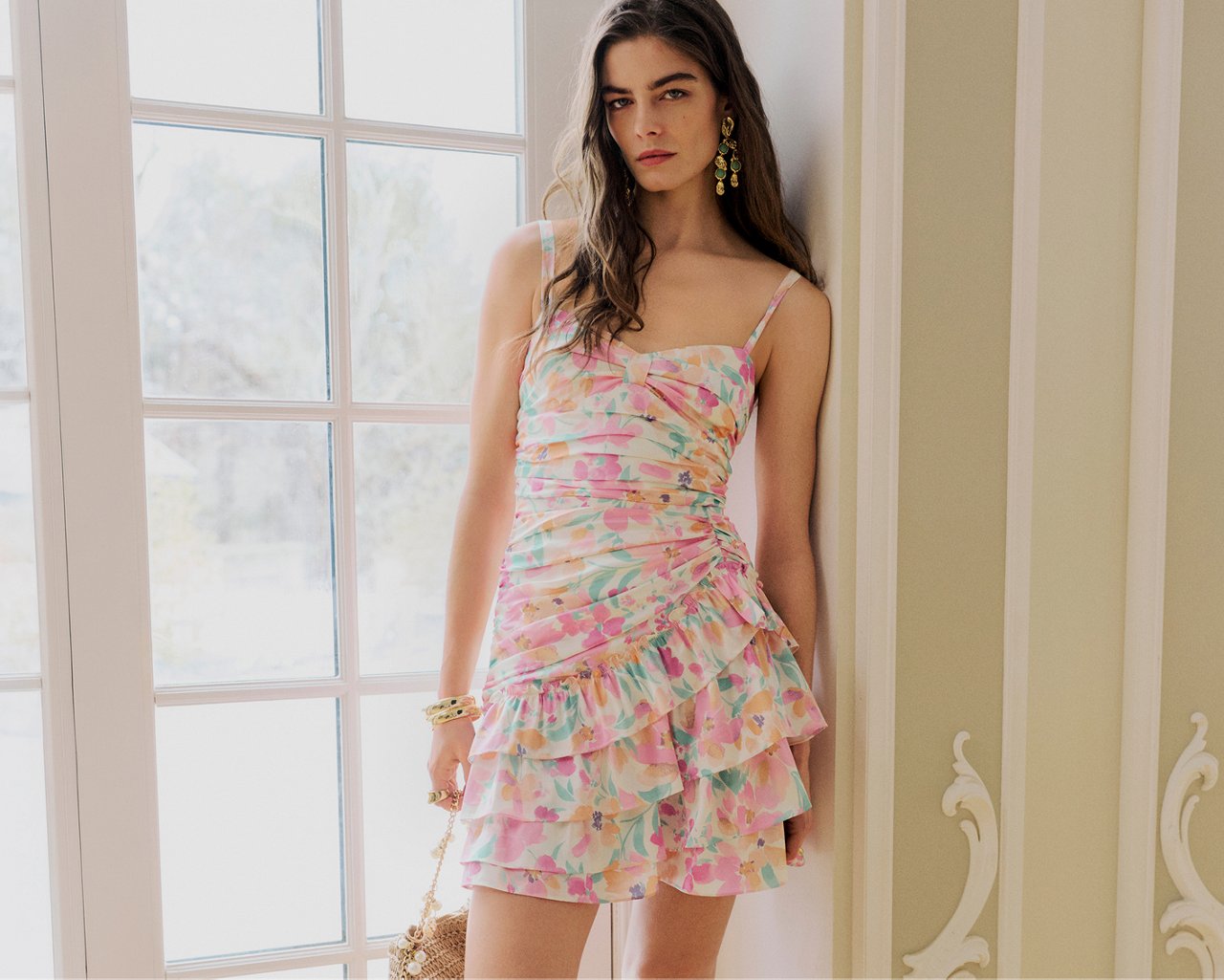 A woman in a pastel printed tiered mini dress with spaghetti straps. New from Aqua. Aqua summer romance.