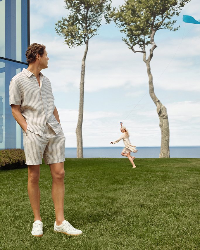A man in a striped short sleeve Vince shirt & matching shorts.