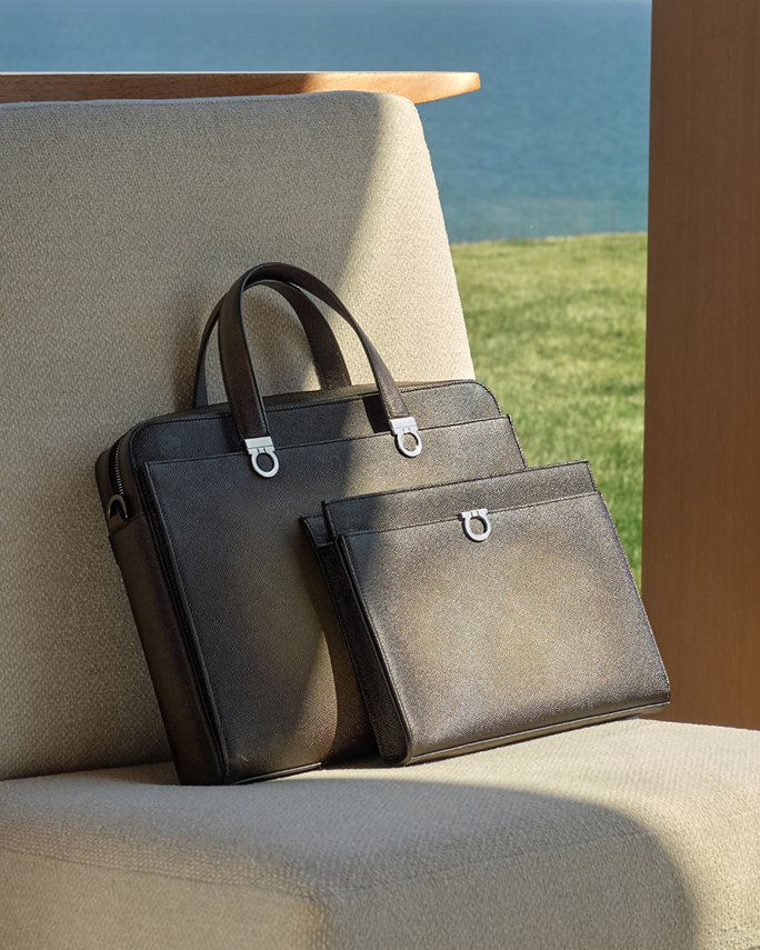 A black leather computer bag and briefcase on a chair. Top fathers day gifts, leather goods.