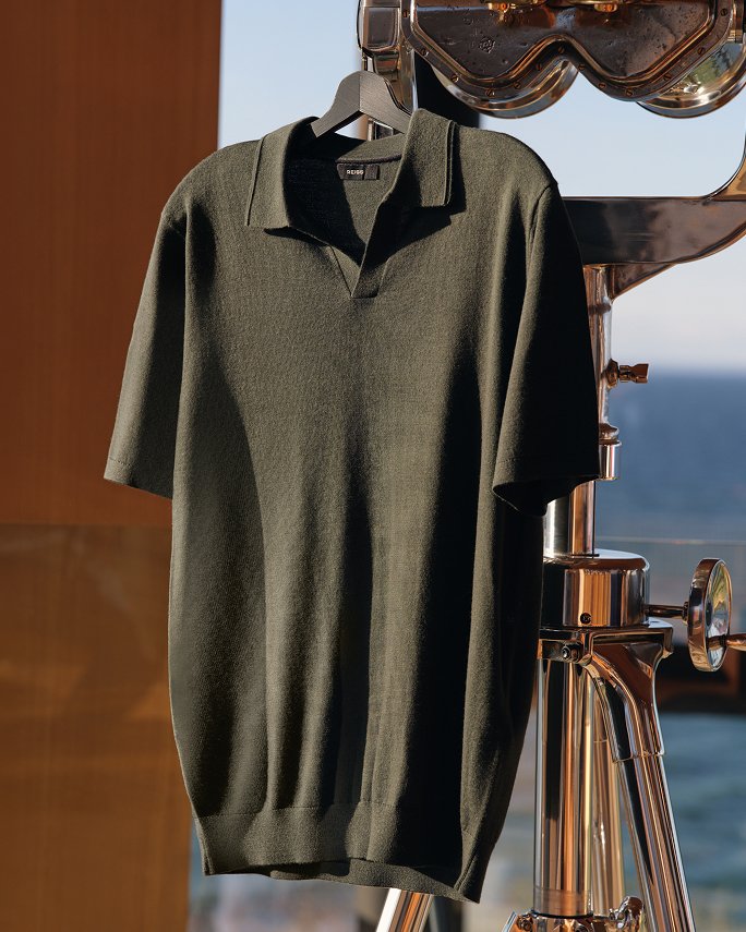 A dark green knit polo hanging from a telescope. Top fathers day gifts, polos.