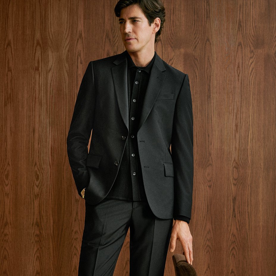 A man in a black suit over a dark casual button down. Lookbooks & guides, the mens suit guide.