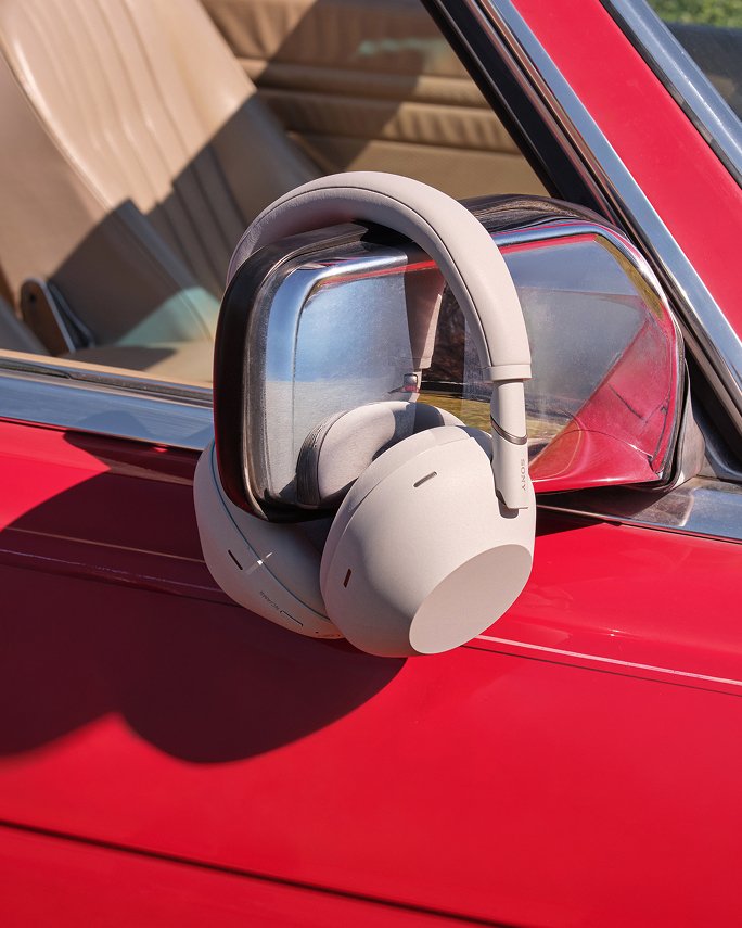 Over the ear headphones hanging from a cars side mirror. Top fathers day gifts, tech accessories.