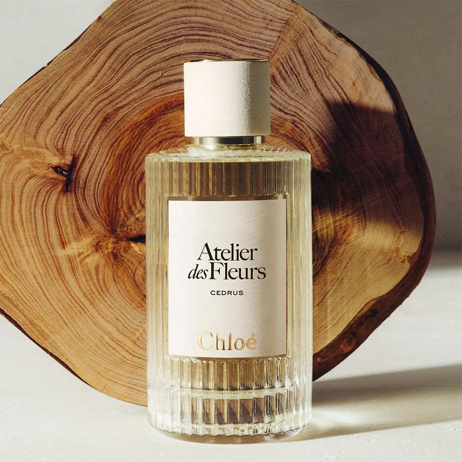 A bottle of Chloe fragrance in front of a chunk of cedarwood. Summer beauty, fragrance.