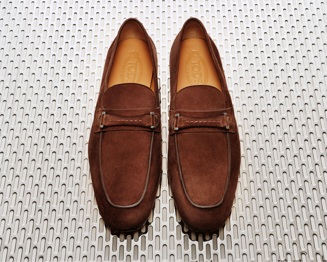 A pair of Tods brown suede loafers. The designer boutique, men.