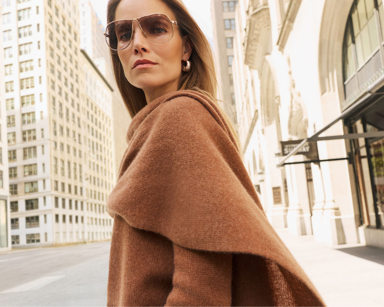 A woman in a brown cashmere sweater with scarf. The cashmere guide, C by Bloomingdales Cashmere.