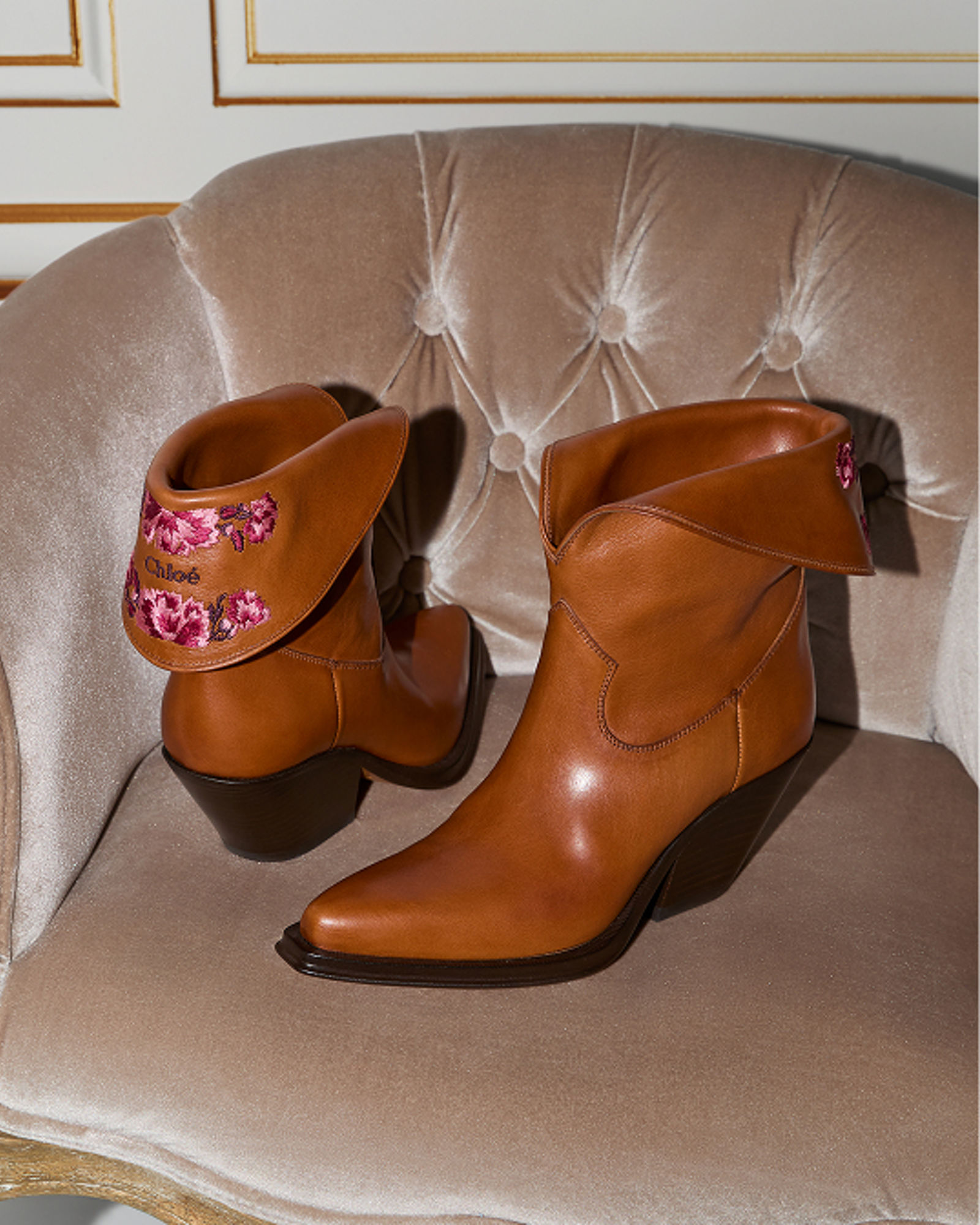 A pair of brown boots on a chair. Get ready for fall. Shop boots.