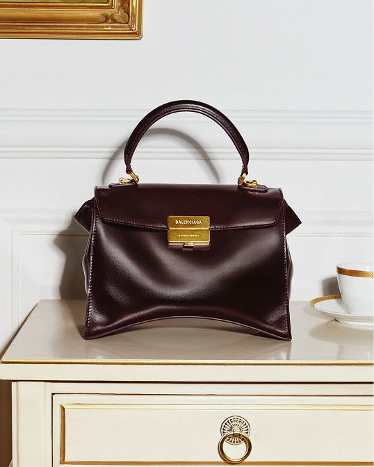 A black structured Balenciaga top handle bag. Shop handbags.