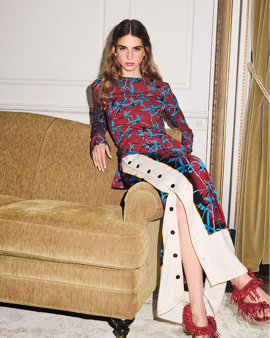 A woman in a vibrant printed long sleeve maxi dress. Shop womens clothing.