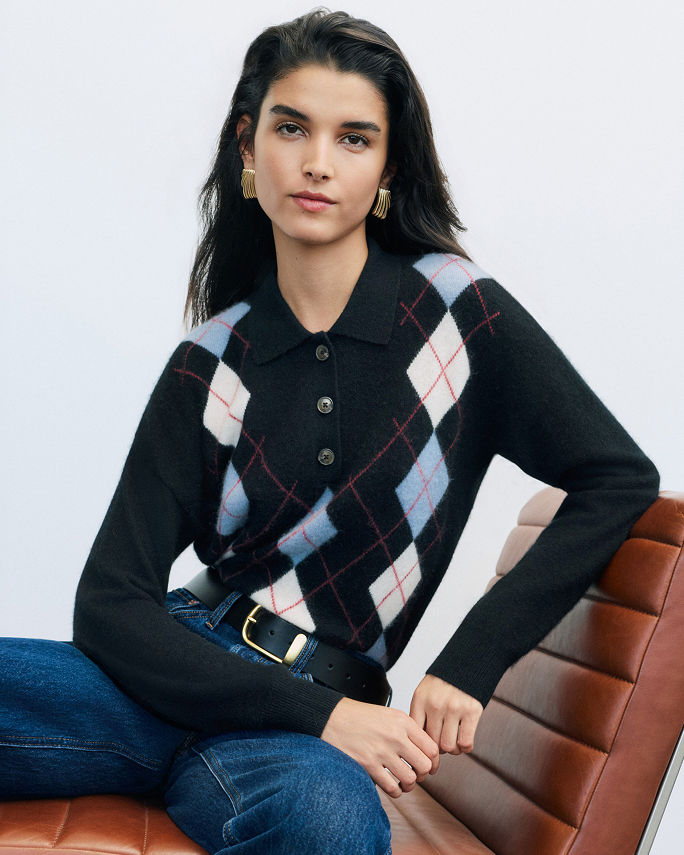 A woman in a blue argyle sweater and jeans. Shop argyle.