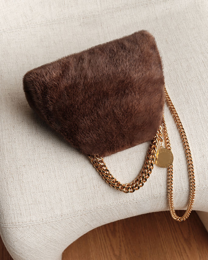A brown faux fur bag with gold chain handle. Shop shearling and faux fur.