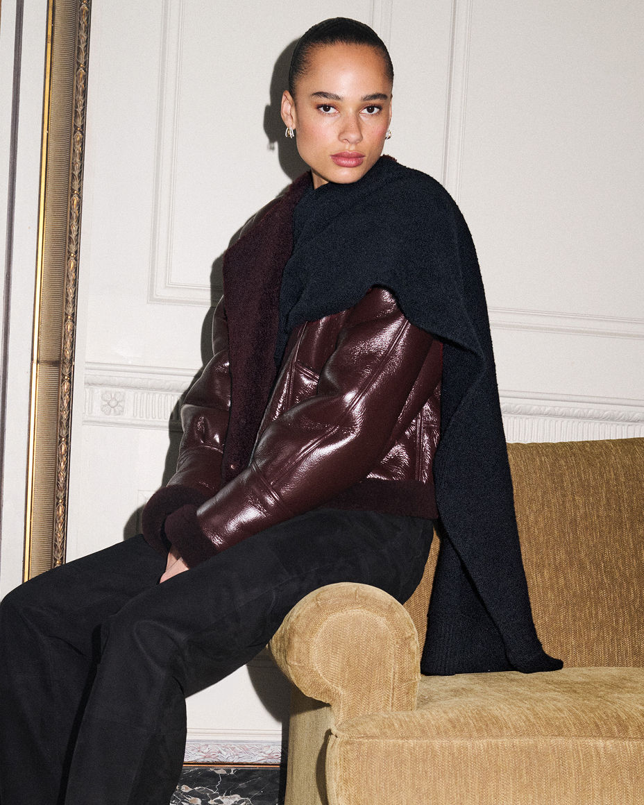 A woman in an Altuzarra burgundy jacket over a black scarf neck top. The fall collections, Altuzarra.